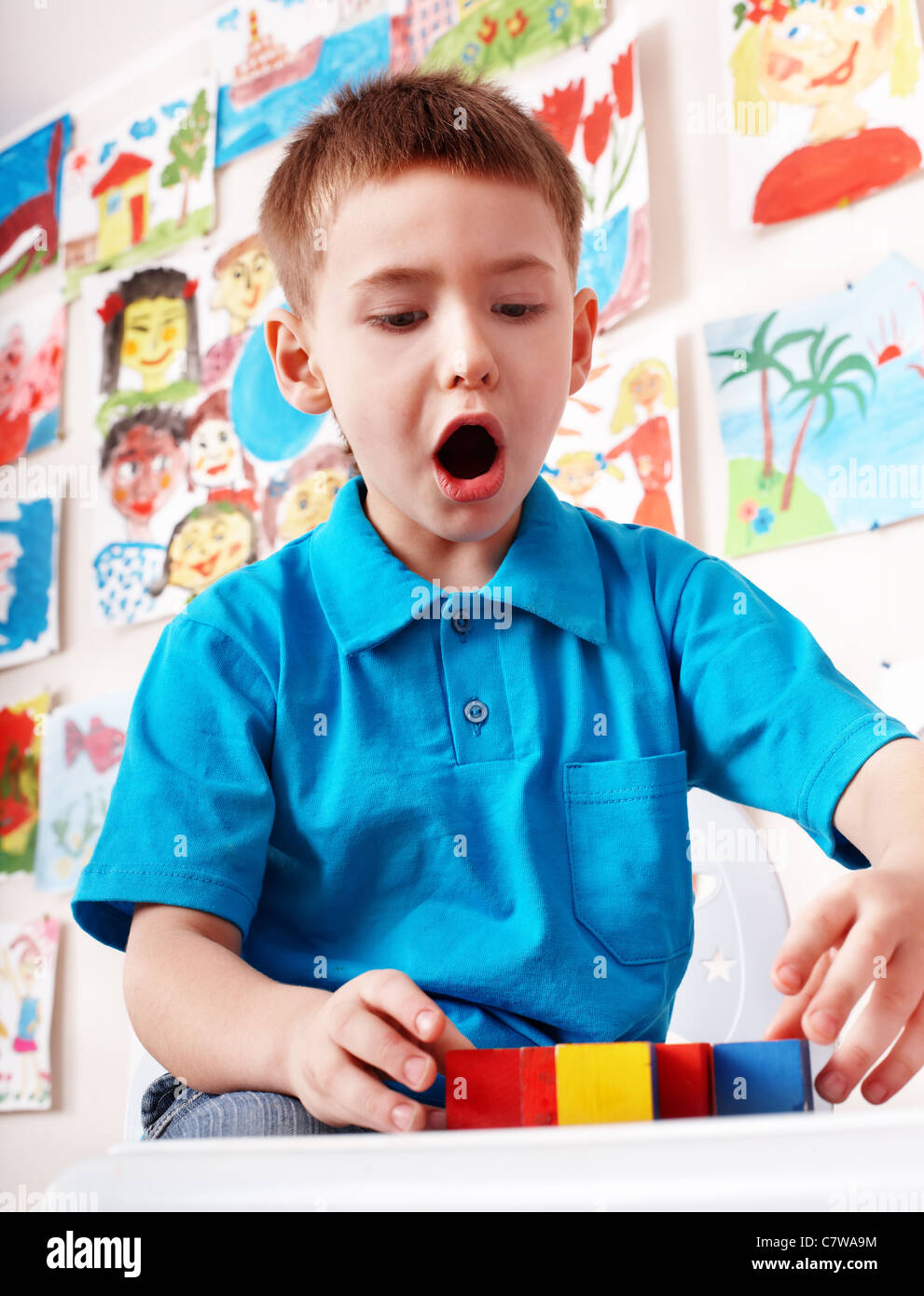 Child with wood block in play room. Preschool Stock Photo - Alamy
