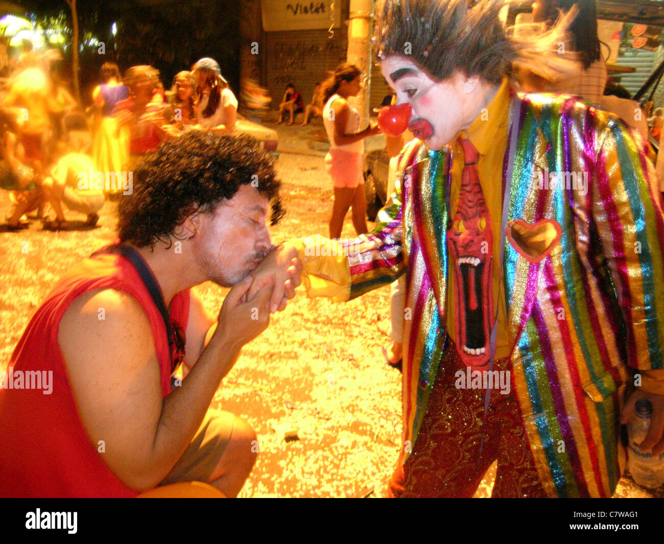 Reveler kissing clown´s hand at Rio de Janeiro street Carnival, Brazil. Carioca lifestyle Stock Photo