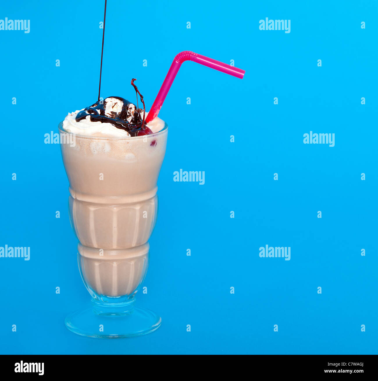 Chocolate shake with a drizzle of chocolate sauce on a blue background Stock Photo