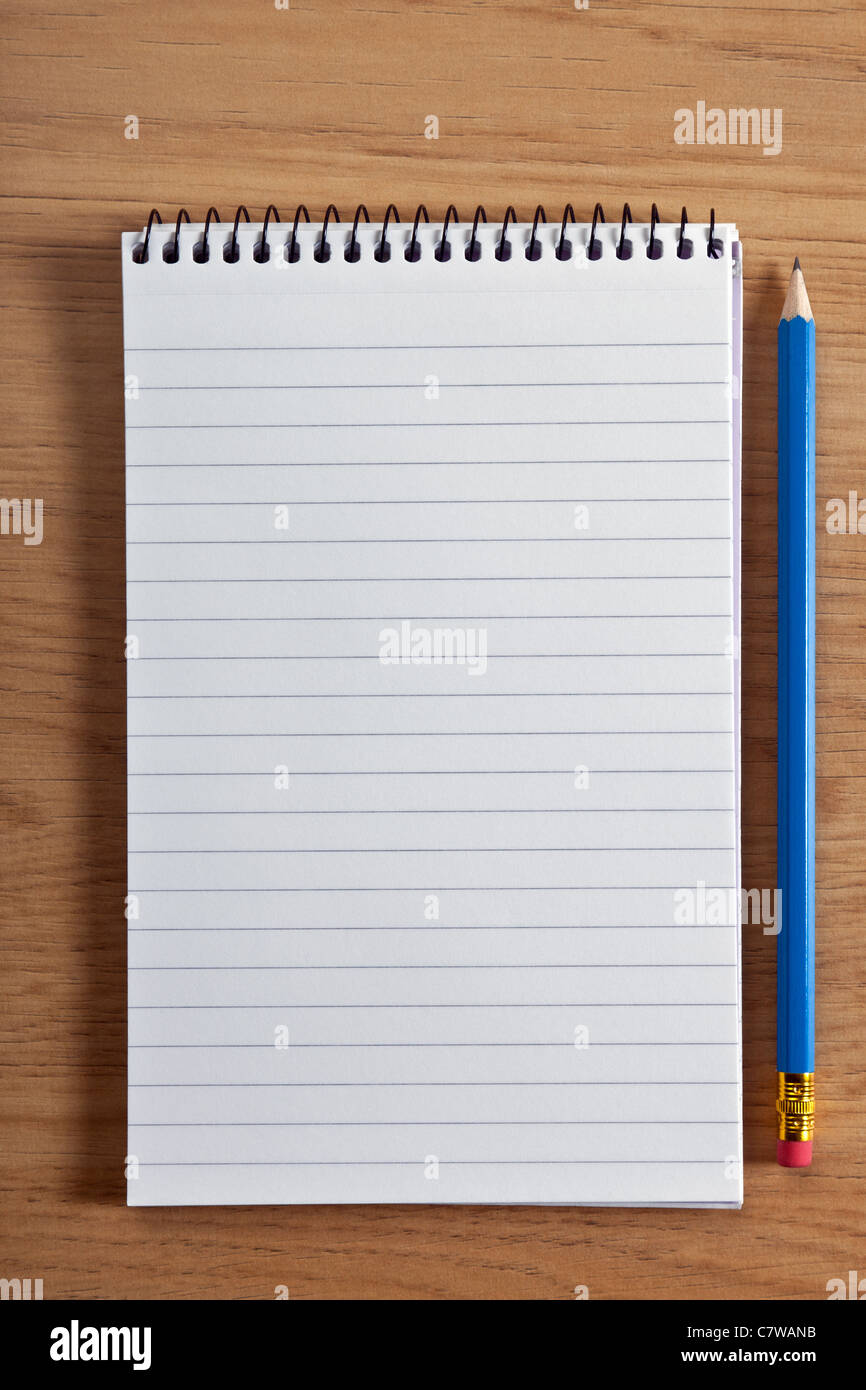 Photo of a blank ruled notepad and pencil on a desk, add your own copy. Stock Photo