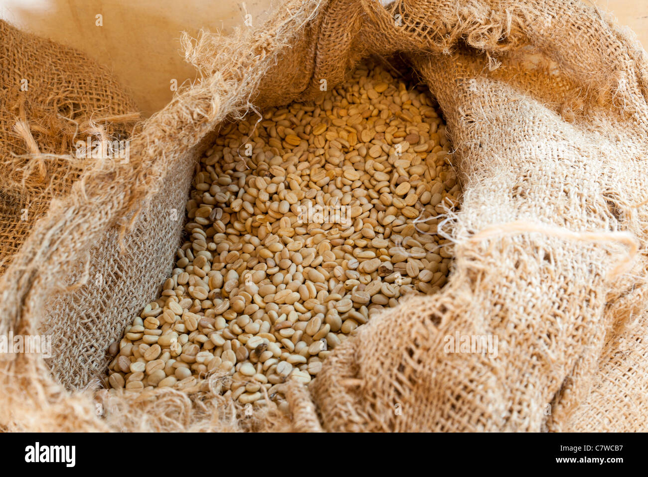 Unroasted coffee beans in a sack Stock Photo - Alamy