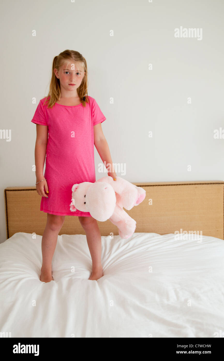 young girl on bed with stuffed animal Stock Photo Alamy