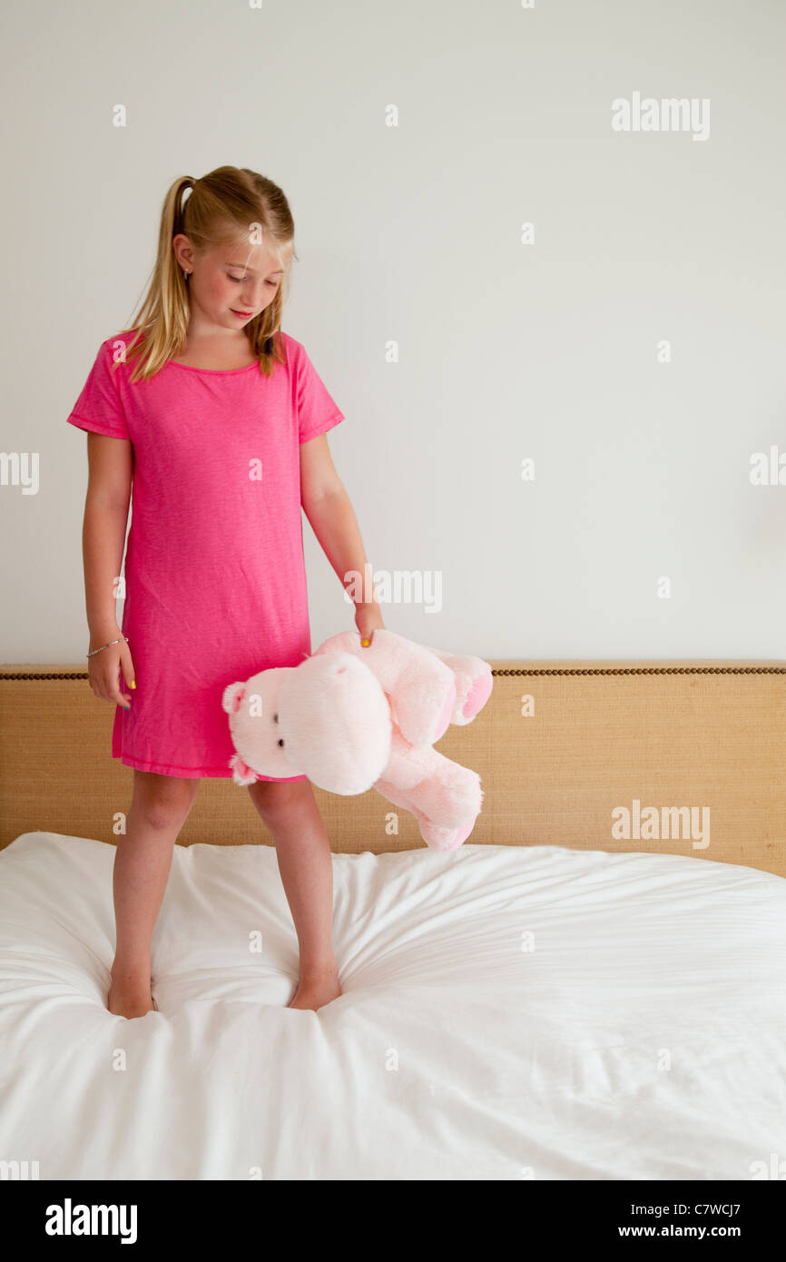 young girl on bed with stuffed animal Stock Photo - Alamy