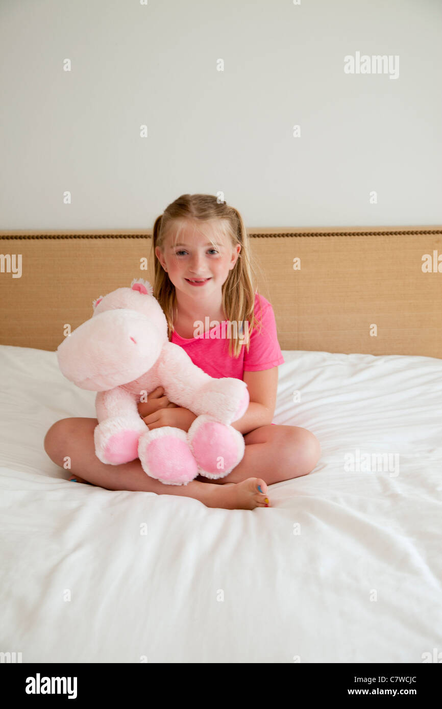 young girl on bed with stuffed animal Stock Photo - Alamy