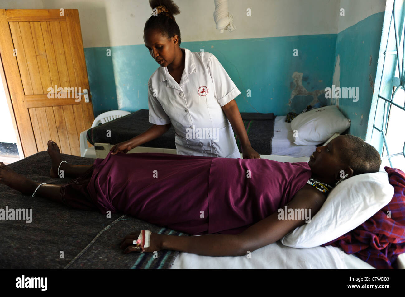 Nurse examining a pregnant Masai woman at a free medical clinic, Meserani, Tanzania. Stock Photo