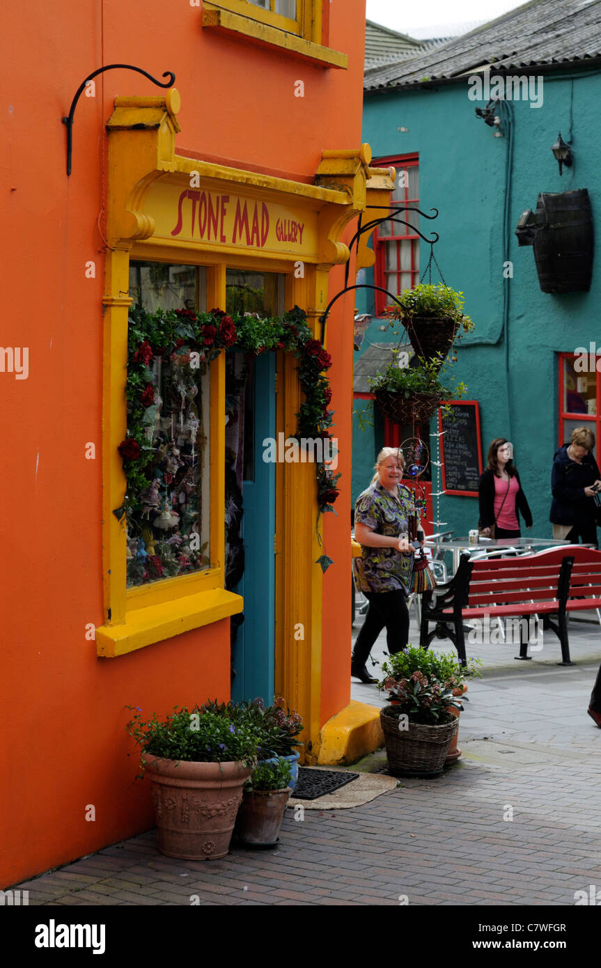 people walking shop shopping street scene kinsale cork ireland brightly coloured colored buildings shops Stock Photo