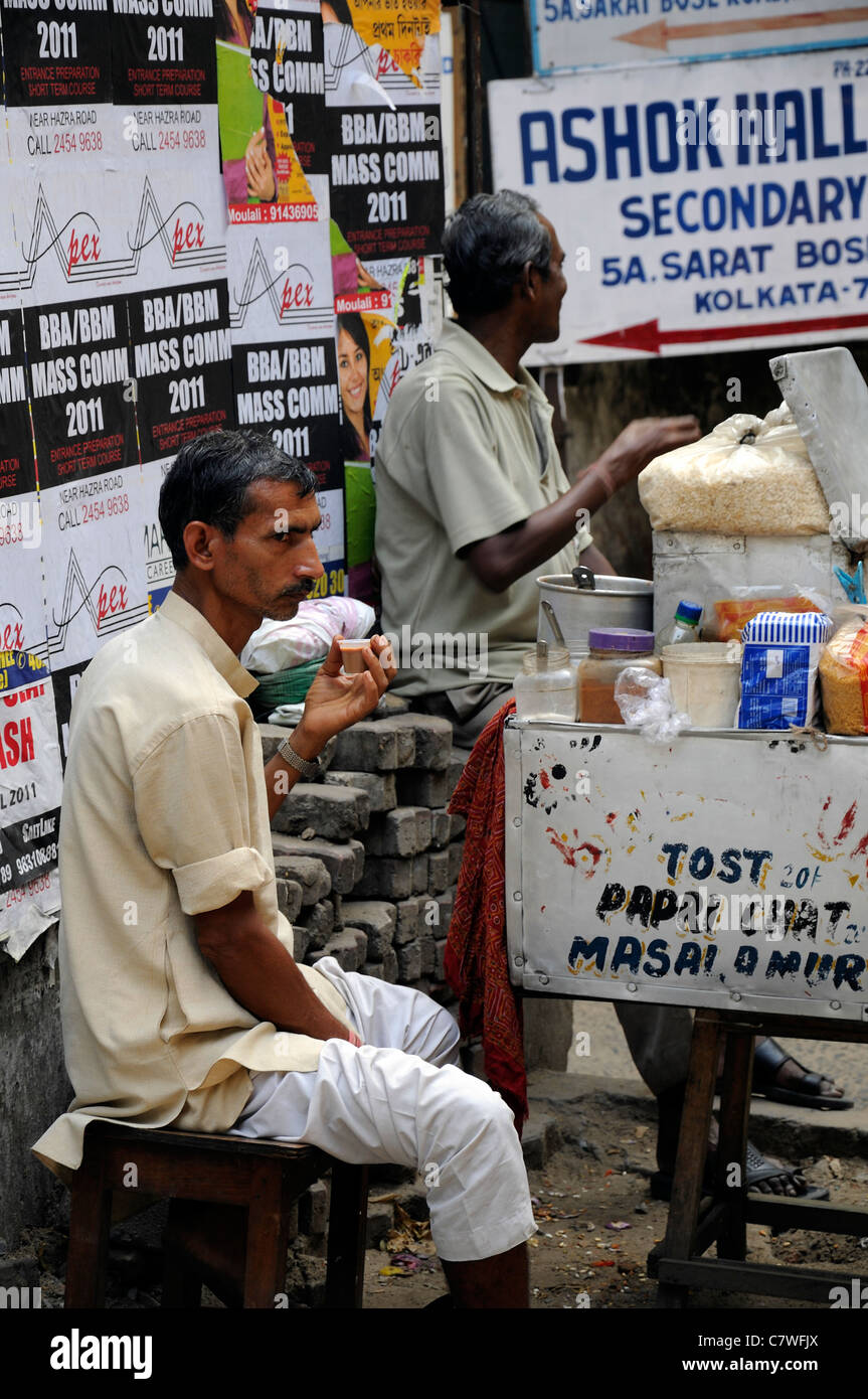 two men drink drinking enjoy enjoying tea chai food stall street stand kolkata calcutta west bengal india Stock Photo