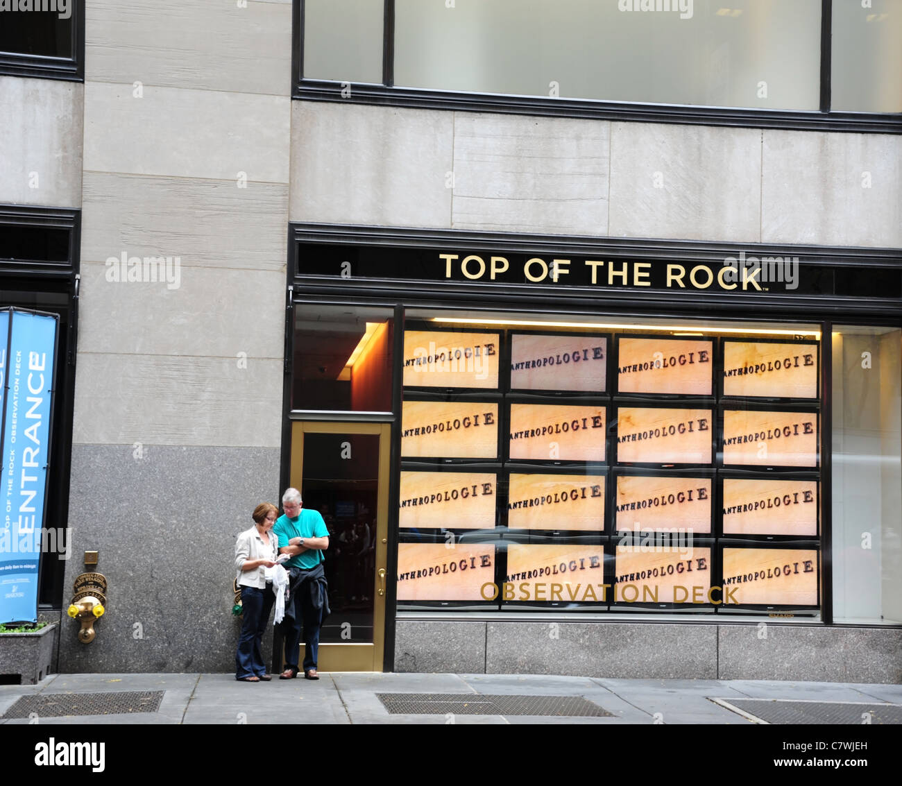 Man woman standing front 50th Street entrance 'Top of the Rock' Observation Deck, GE Building, Rockefeller Centre, New York City Stock Photo