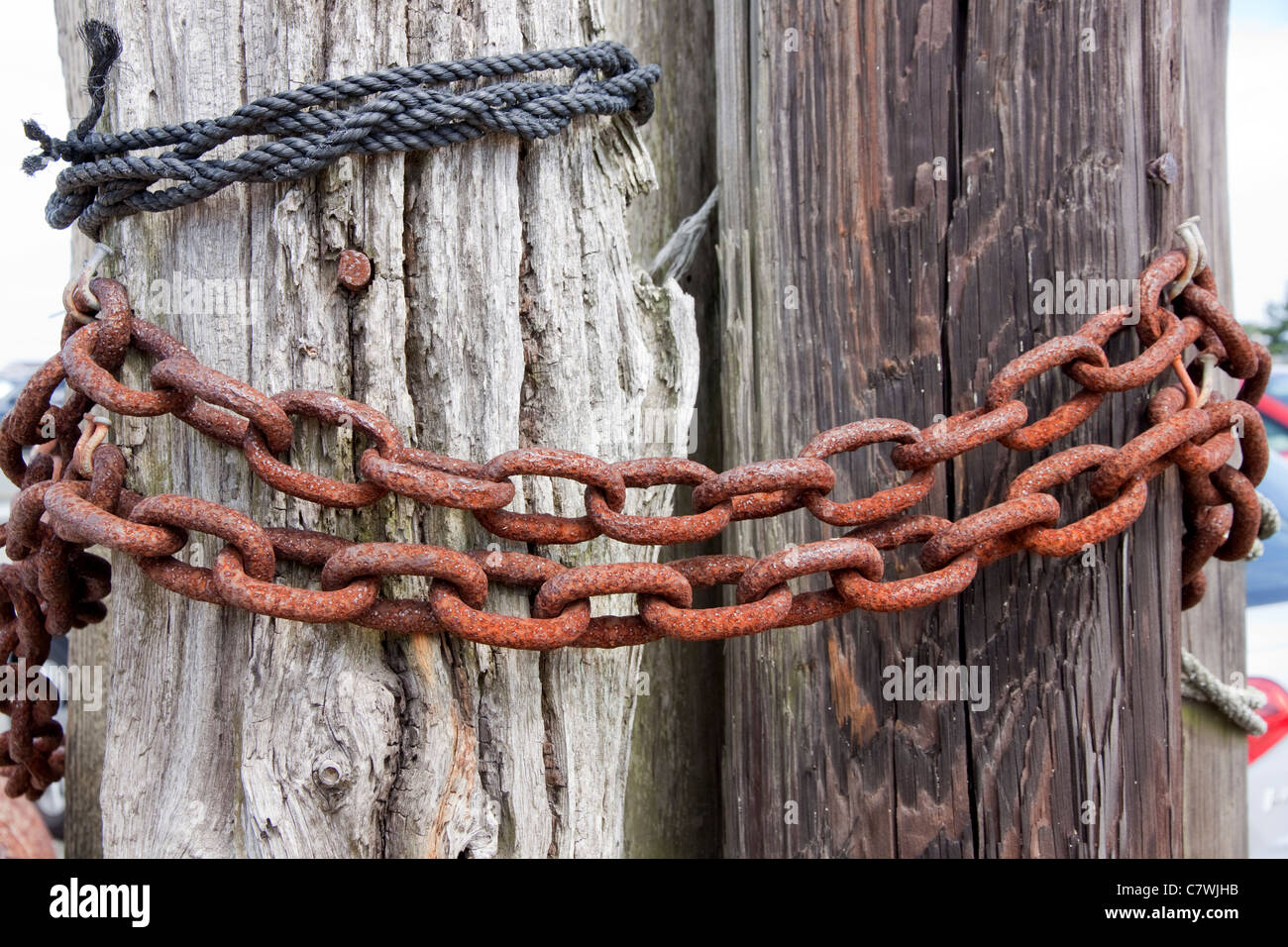 Rusty chain links on wooden poles. Stock Photo