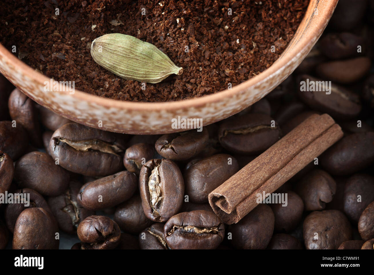 Full frame image of coffee beans and powdered coffee with cinnamon and cardamom, the ingredients for Indian coffee. Stock Photo