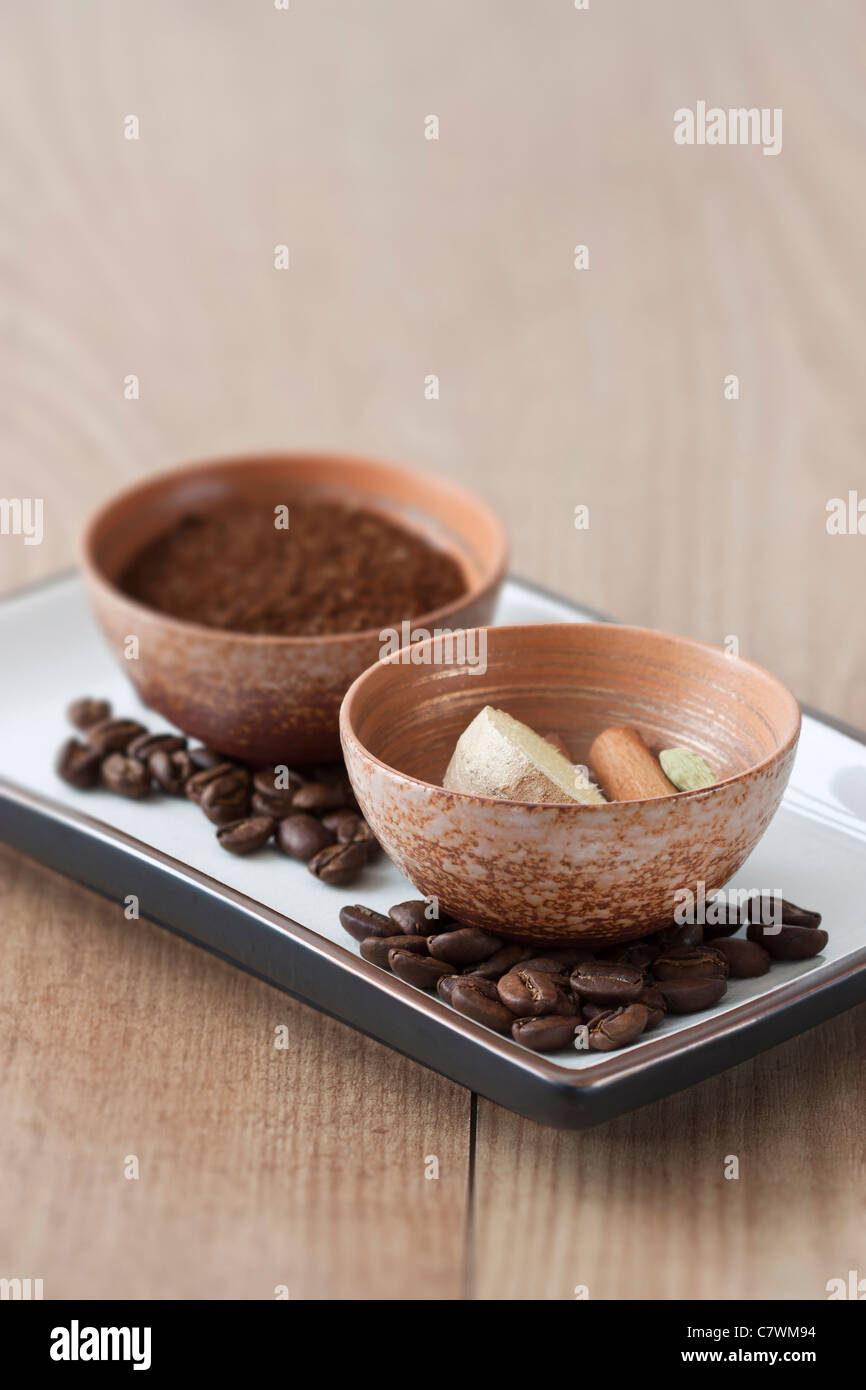 Bowls with powdered coffee and ginger, cinnamon and cardamom, the ingredients for Indian coffee. Stock Photo