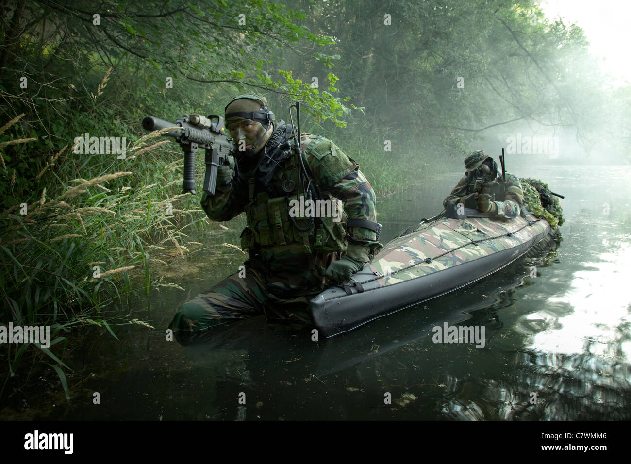 Navy SEALs navigate the waters in a folding kayak during jungle warfare operations. Stock Photo