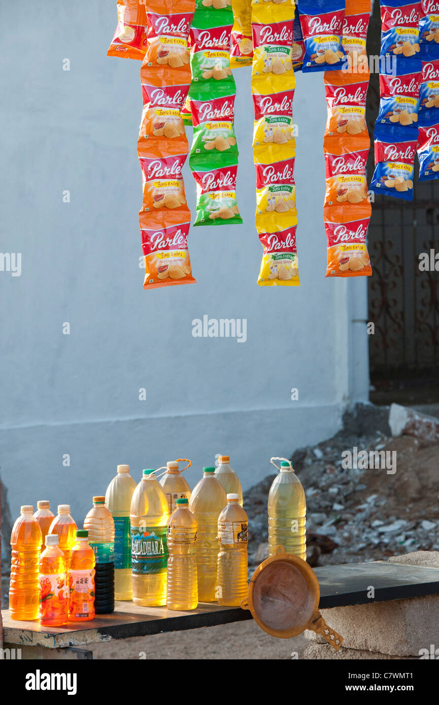 Indian petrol sold in plastic bottles with packets of crisps outside a shop. Puttaparthi, Andhra Pradesh, India Stock Photo