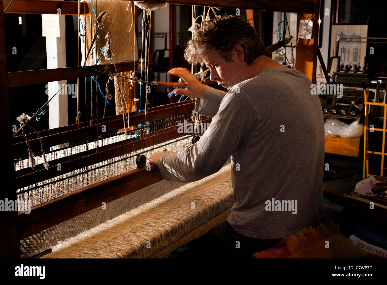Ireland, Co Wicklow, Avoca Handweavers Mill, weaver weaving cloth on traditional fly shuttle hand loom Stock Photo