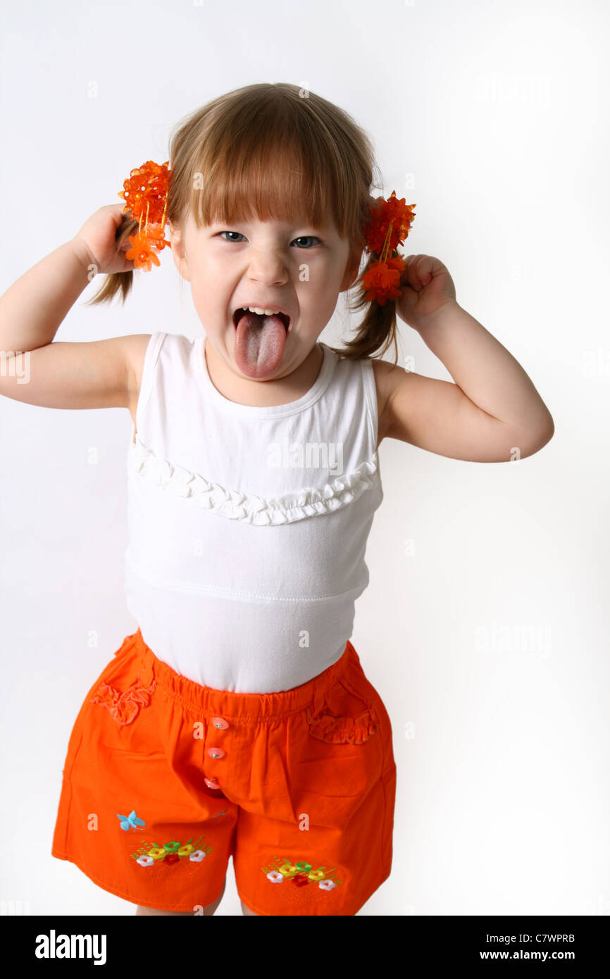 Head and hands shot of Little girl sticking out her tongue at the camera for fun Stock Photo