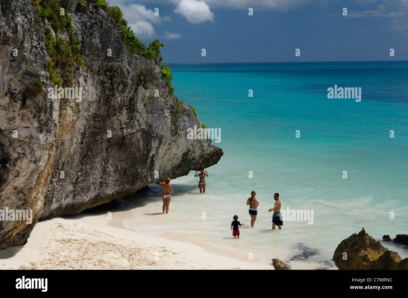 Family and girlfriends playing in the surf by the sea cliffs of Tulum Mexico Mayan Riviera Yucatan Peninsula Caribbean Stock Photo