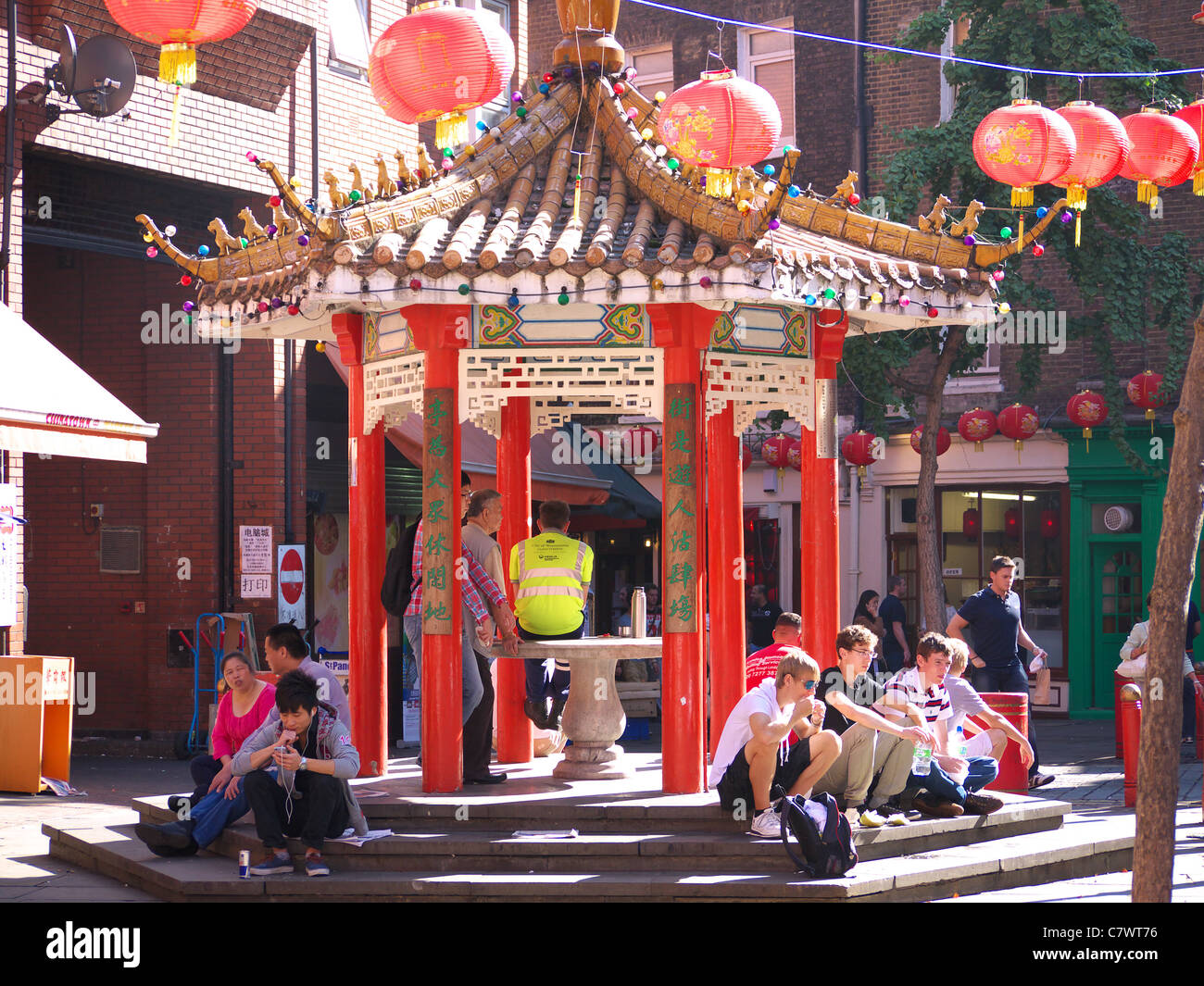 People sitting around a pagoda in Newport Street in London's Chinatown Stock Photo