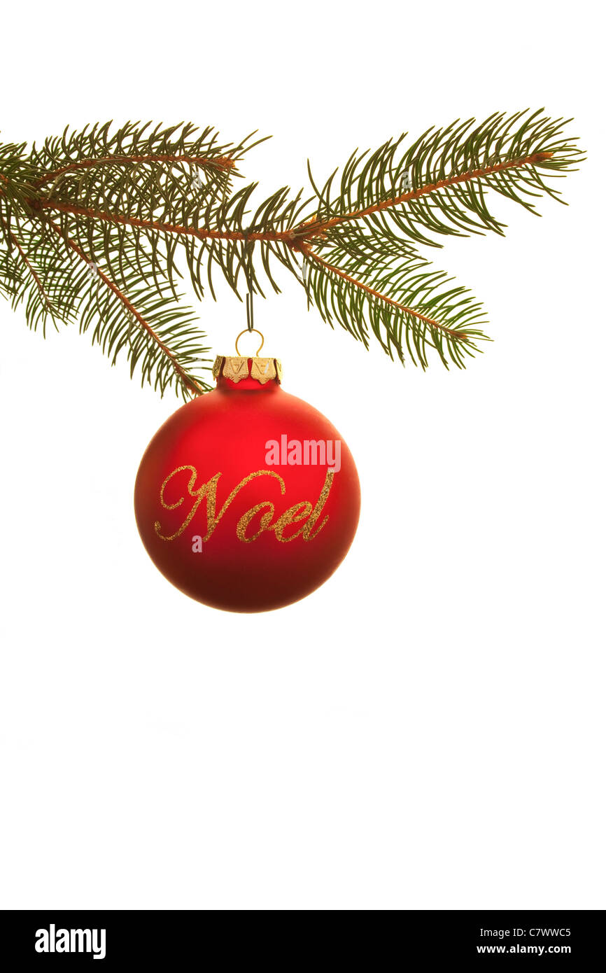Christmas ornament with the Noel written on it in cursive hanging from a pine branch Stock Photo