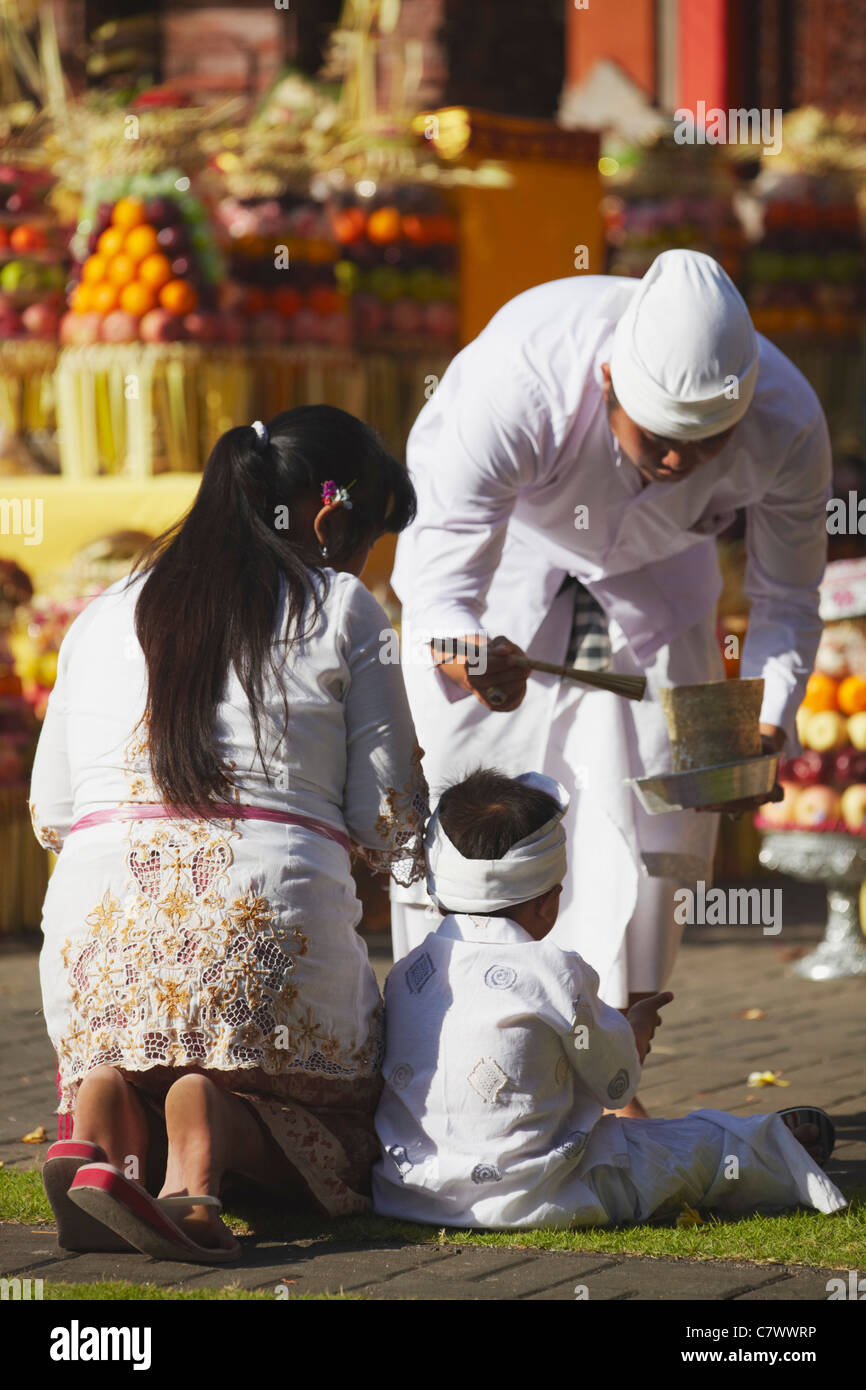 Children receiving blessing from priest at temple ceremony, Bali