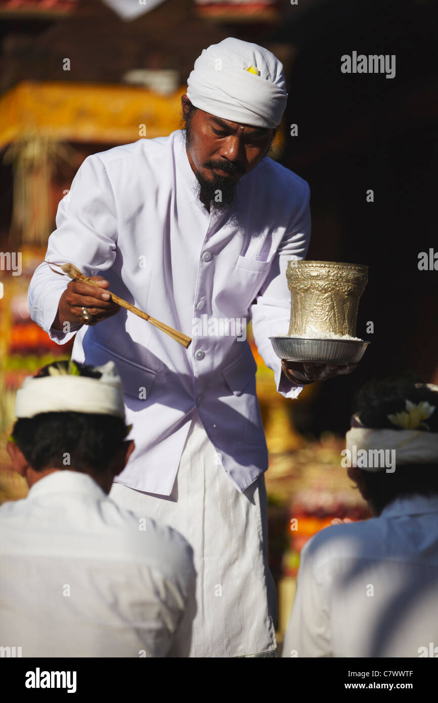 People receiving blessing from priest at temple ceremony, Bali ...