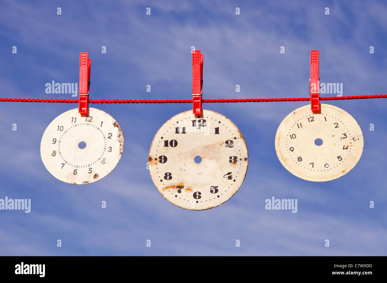 three clocks dials on red string and sky Stock Photo Alamy