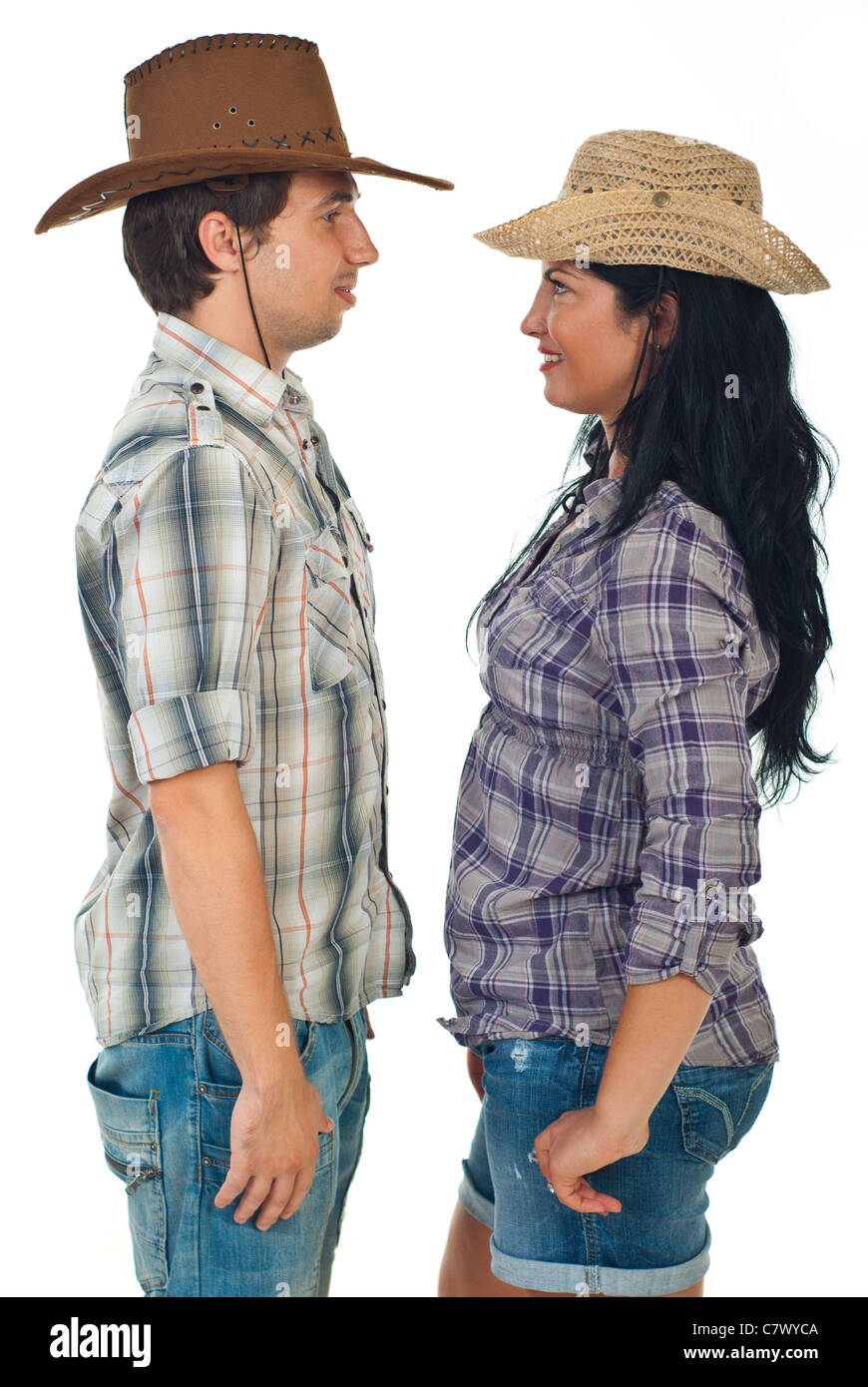 Couple wearing cowboy hats and standing face to face isolated on white background Stock Photo