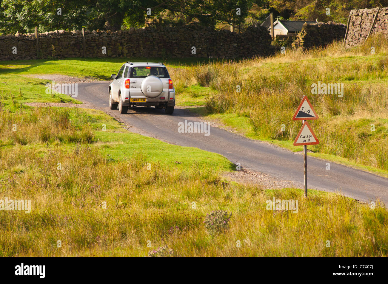 A car goes down a 1 in 4 hill in Low Row in Swaledale in North Yorkshire , England , Britain , Uk Stock Photo