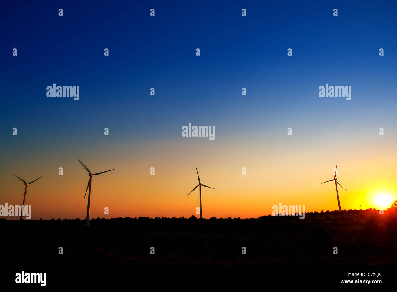 aerogenerator windmills on sunset sky background Stock Photo