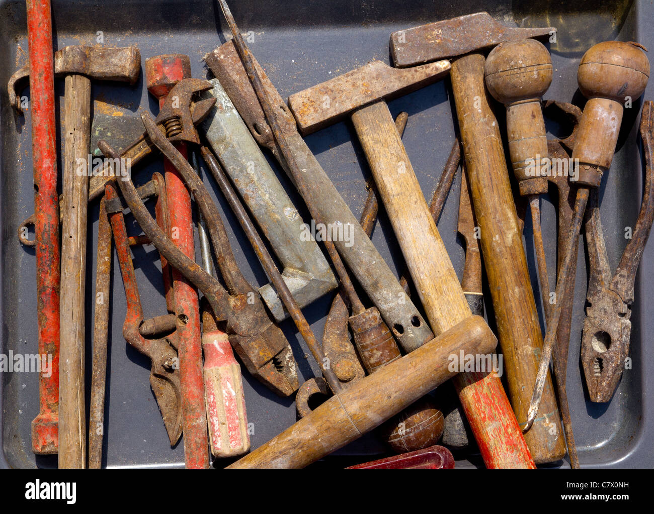 aged weathered rusty hand tools in black iron tray Stock Photo - Alamy