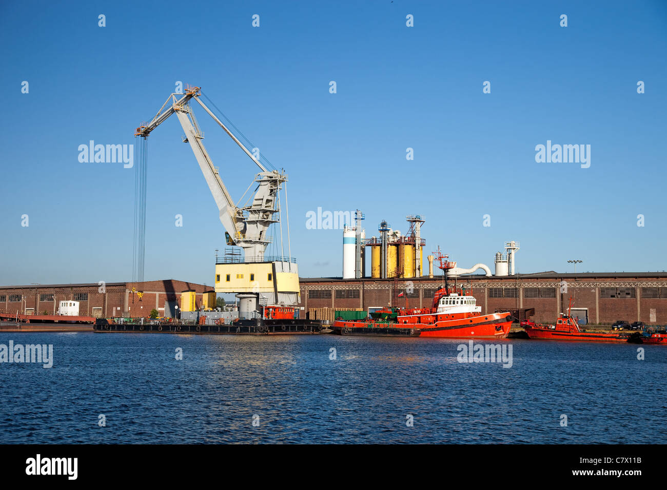 Floating crane standing on the waterfront of the port. Stock Photo