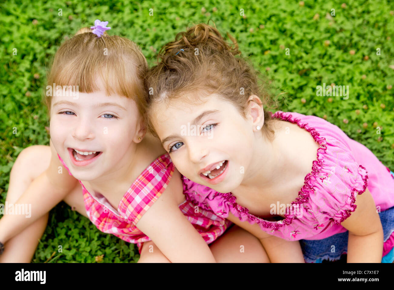 Children Girls Laughing Sitting On Green Grass Park Stock Photo   Alamy