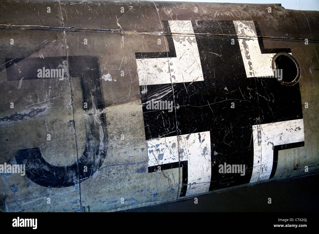 The Luftwaffe Balkenkreuz on the fuselage of a crashed German WW2 aircraft. Scratched and distressed markings cover the surface. Stock Photo