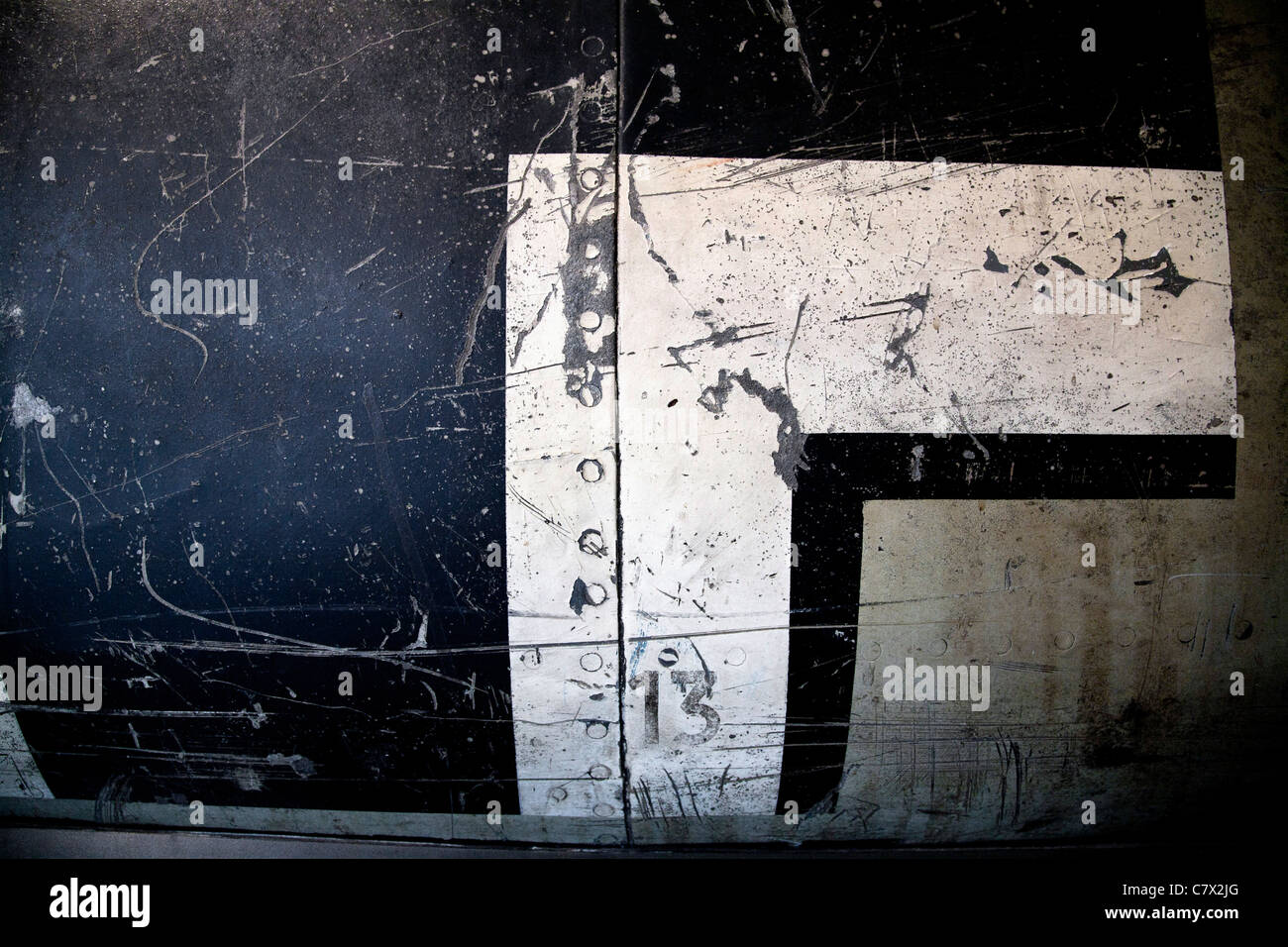 The Luftwaffe Balkenkreuz on the fuselage of a crashed German WW2 aircraft. Scratched and distressed markings cover the surface. Stock Photo