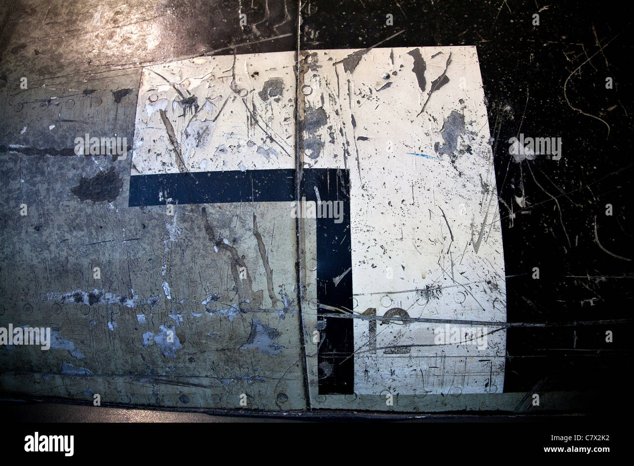 The Luftwaffe Balkenkreuz on the fuselage of a crashed German WW2 aircraft. Scratched and distressed markings cover the surface. Stock Photo