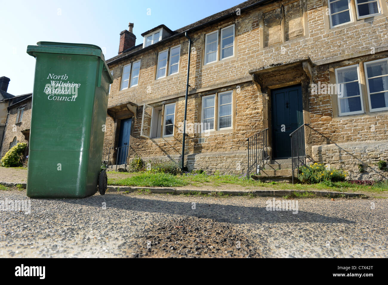 Green rubbish bin in village street Lacock Wiltshire Uk Stock Photo