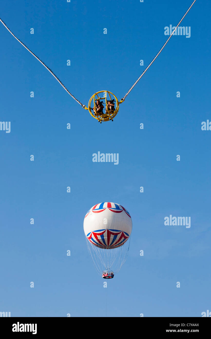 A fairground ride flings members of the public high into the air, not far from the Bournemouth Balloon. Stock Photo