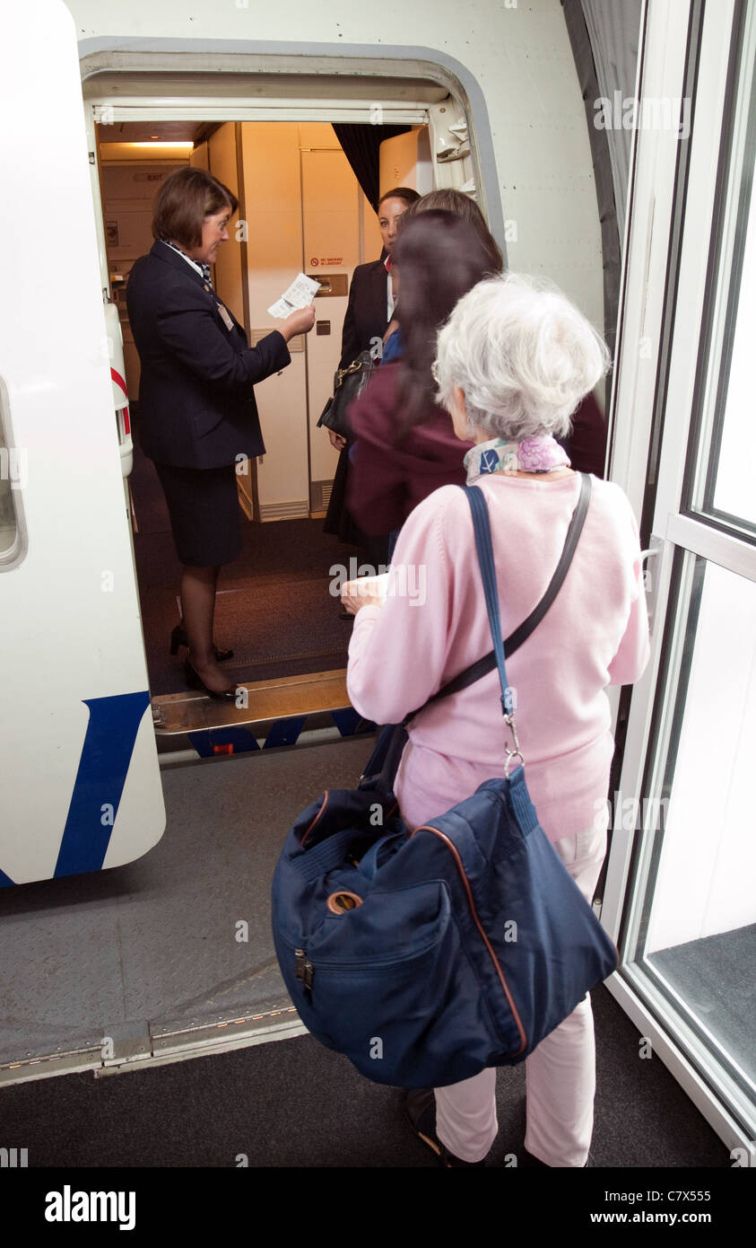 Elderly lady boarding a BA plane, Heathrow airport London UK Stock Photo