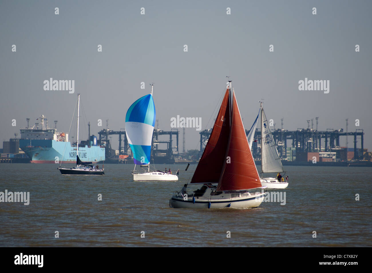 Sailing boats Harwick Felixstowe Harbour  with container port Stock Photo