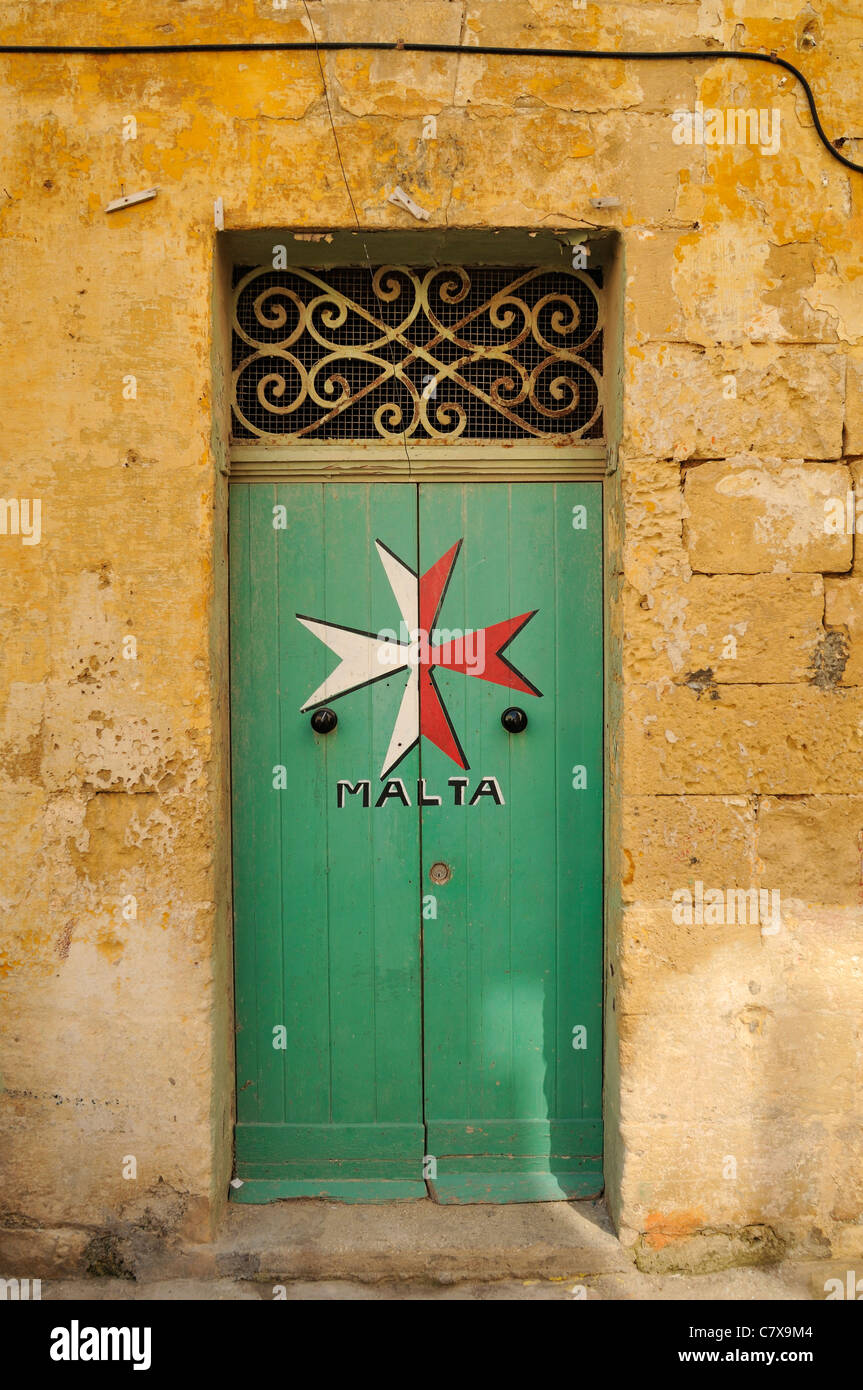 Maltese Cross painted on a old green doorway, Malta. Stock Photo