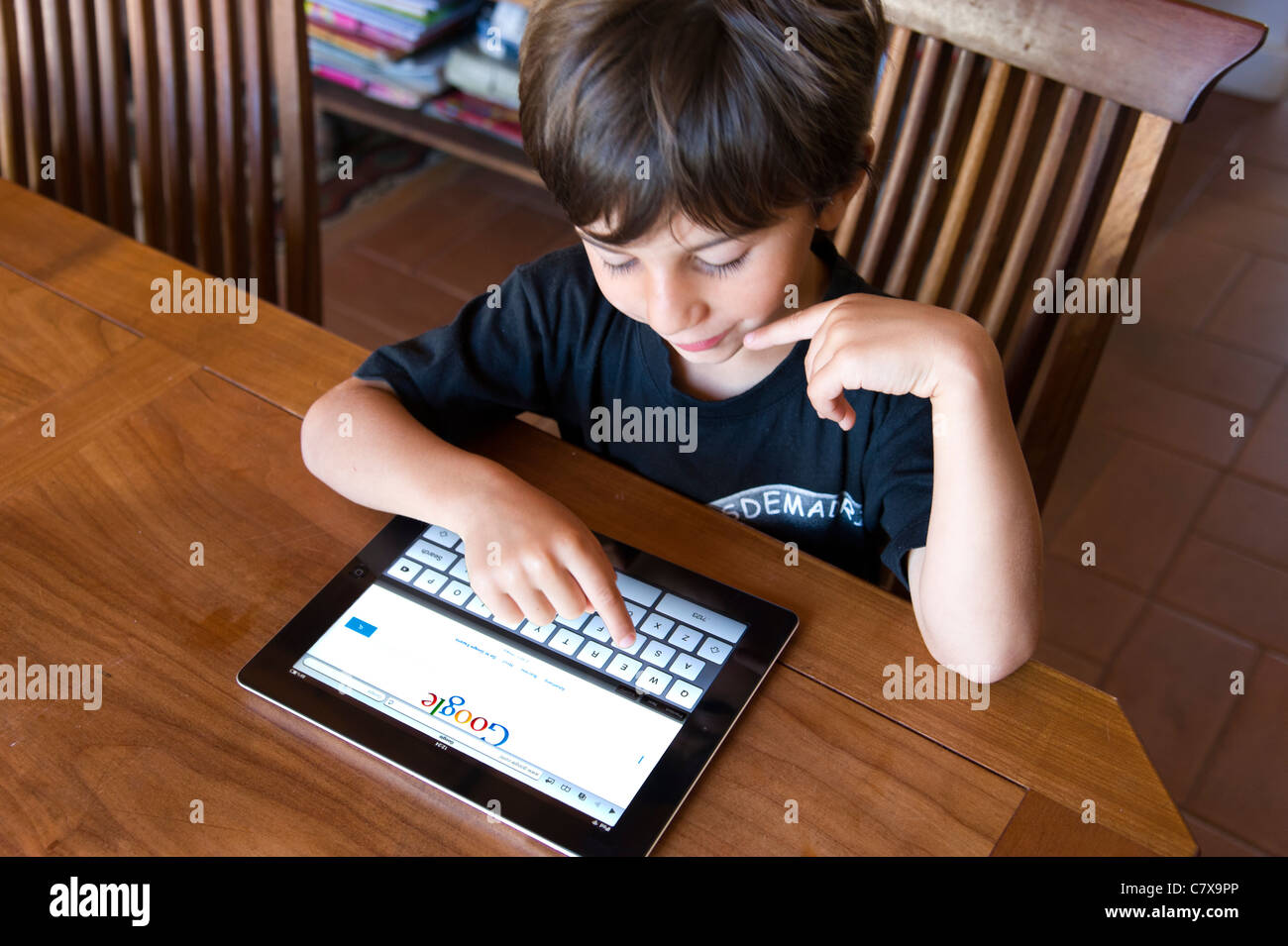 Child using Apple iPad 2 tablet computer at home Stock Photo