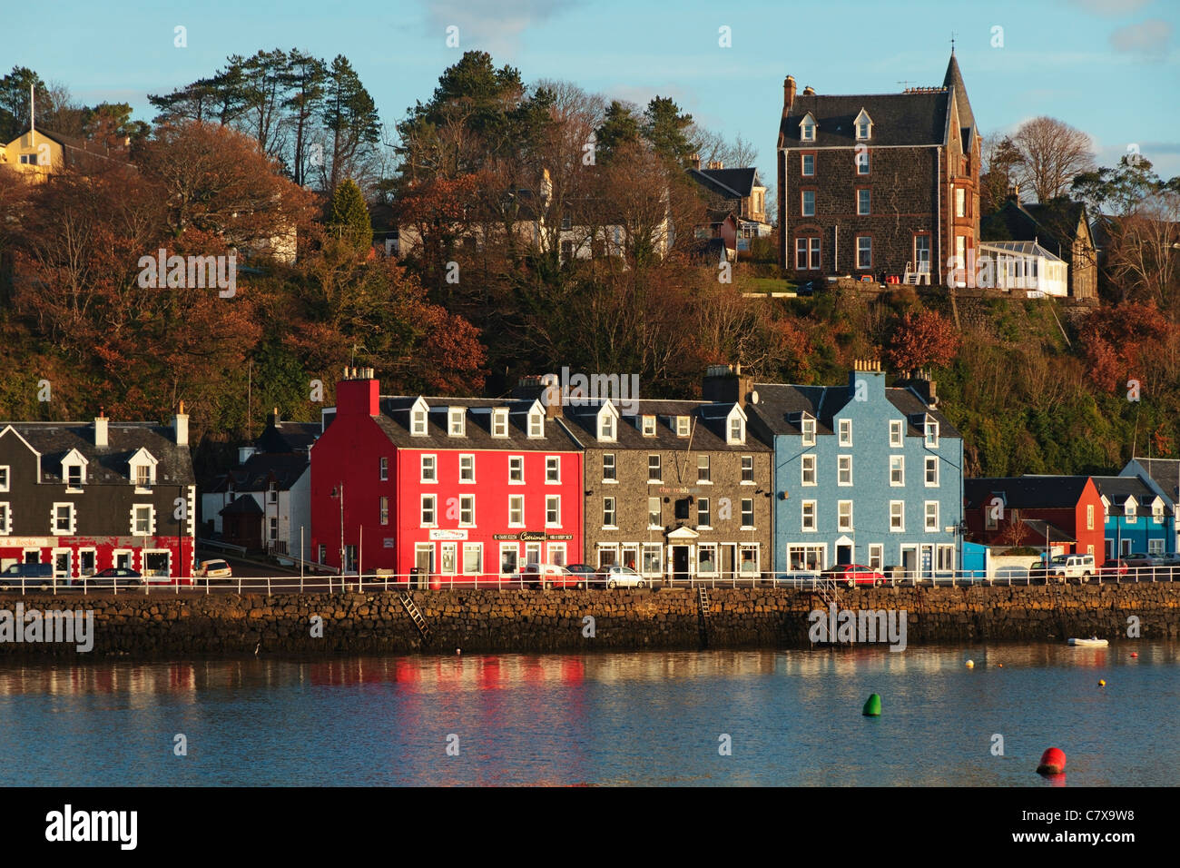Colourful houses along Tobermory quayside reflecting in the still