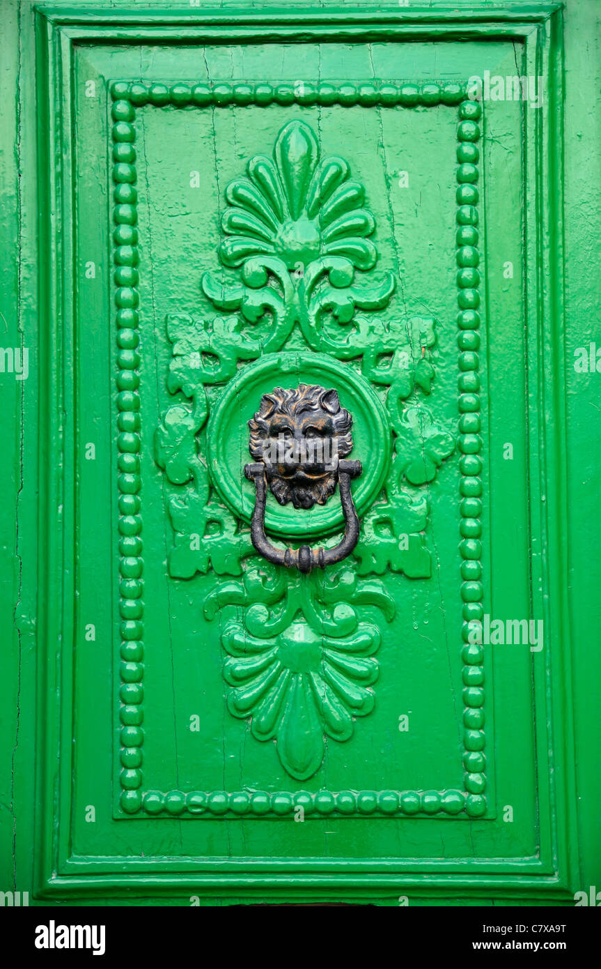 Black lion head door knocker on green door in Valletta, Malta. Stock Photo