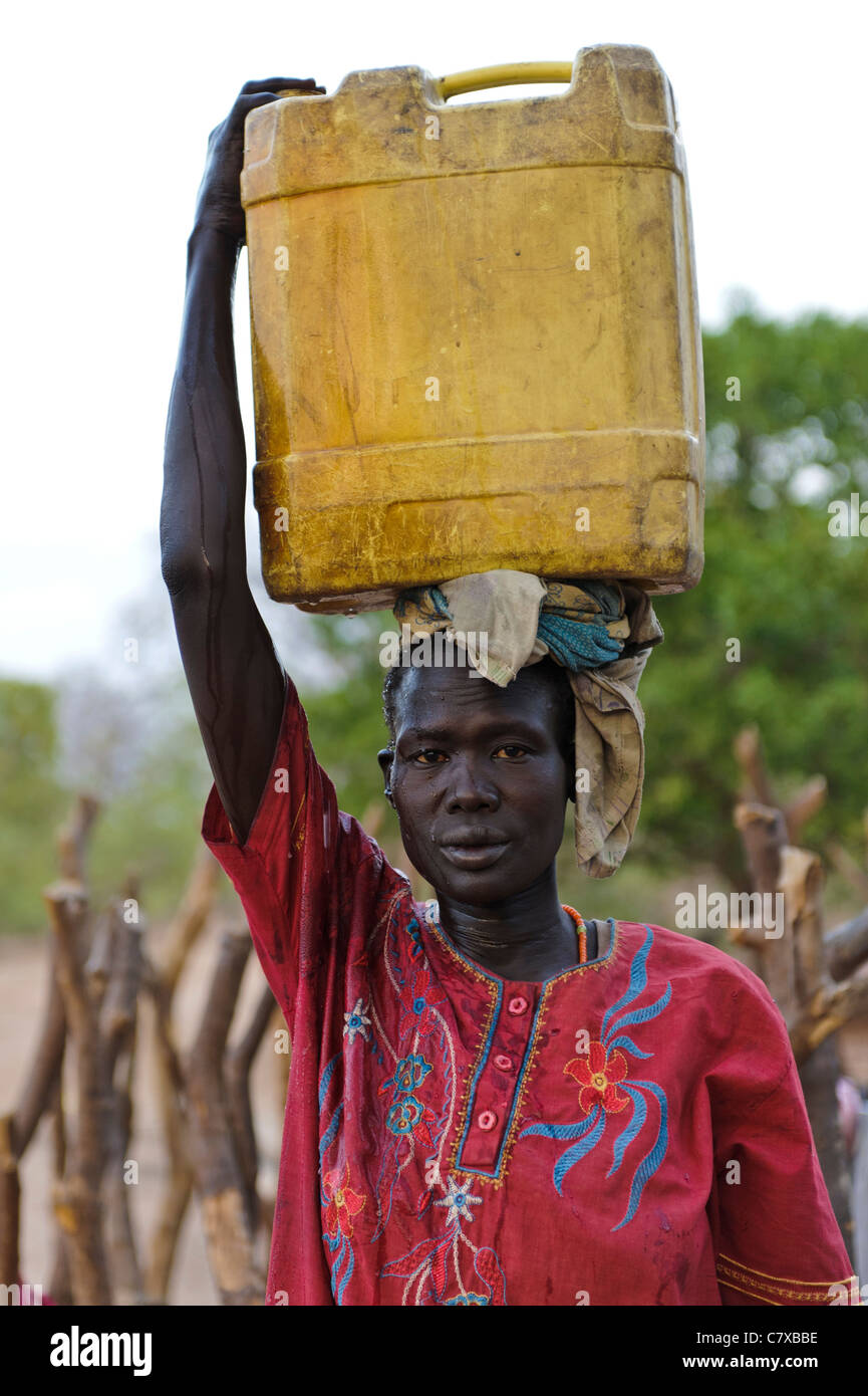 Women carrying water back from a borehole, Luonyaker, Bahr el Ghazal, South Sudan. Stock Photo