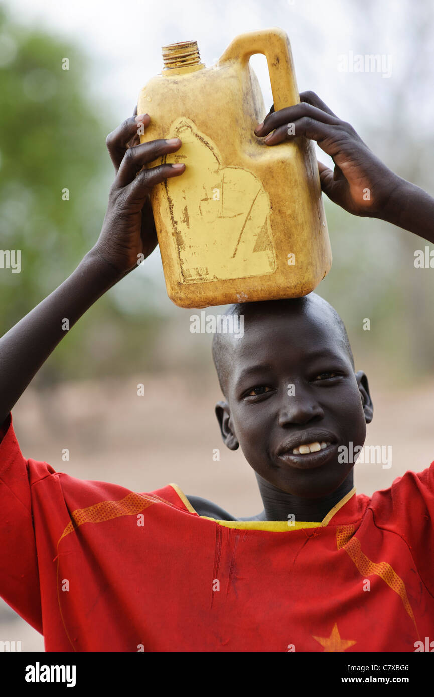 A boy carrying water back from a borehole, Luonyaker, Bahr el Ghazal, South Sudan. Stock Photo
