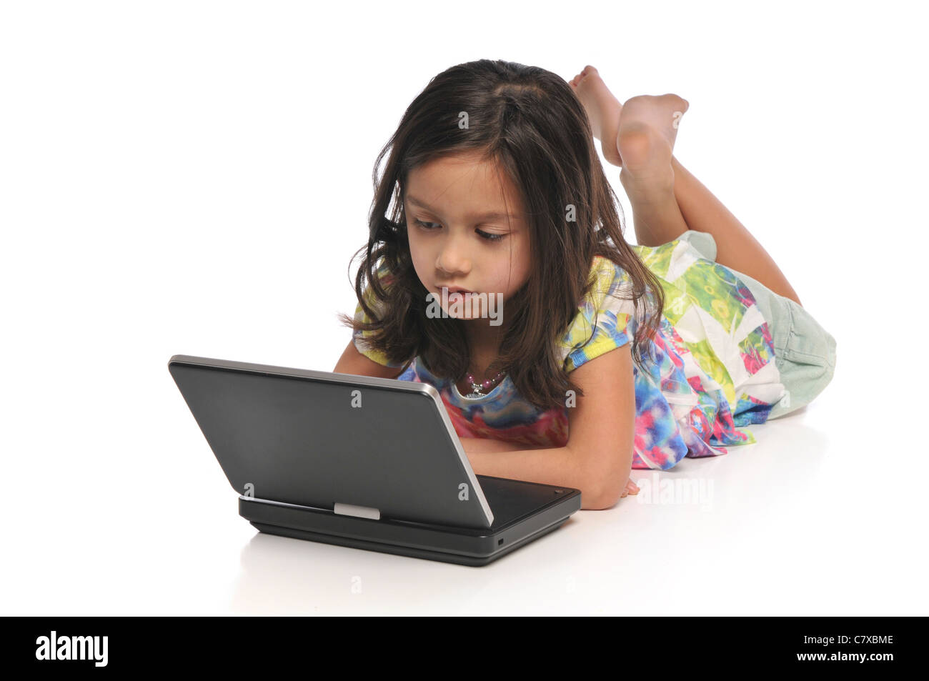 Little girls with a laptop computer isolated on a white background ...