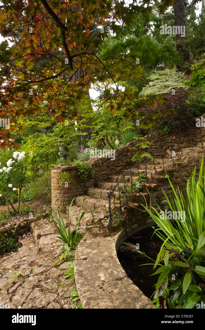 Ornate stone steps amongst the landscaped gardens of Kiftsgate Court near Chipping Campden, Cotswolds, Gloucestershire, England Stock Photo