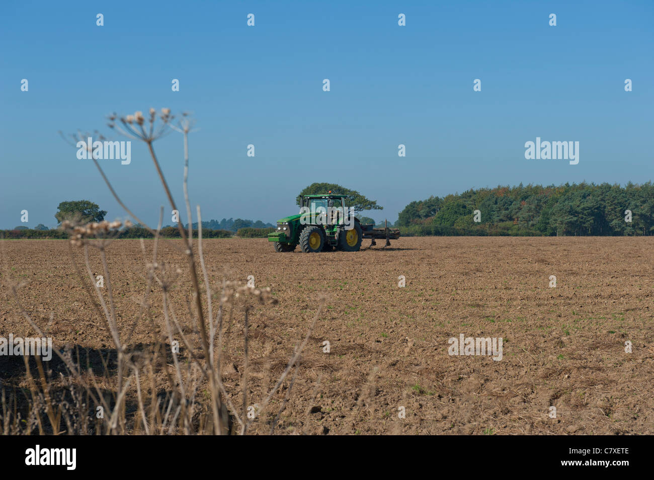 Tractor with harrow in ploughed field Stock Photo - Alamy