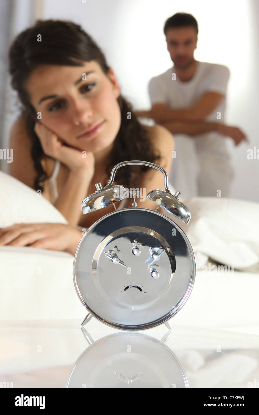 Couple staring at an alarm clock Stock Photo