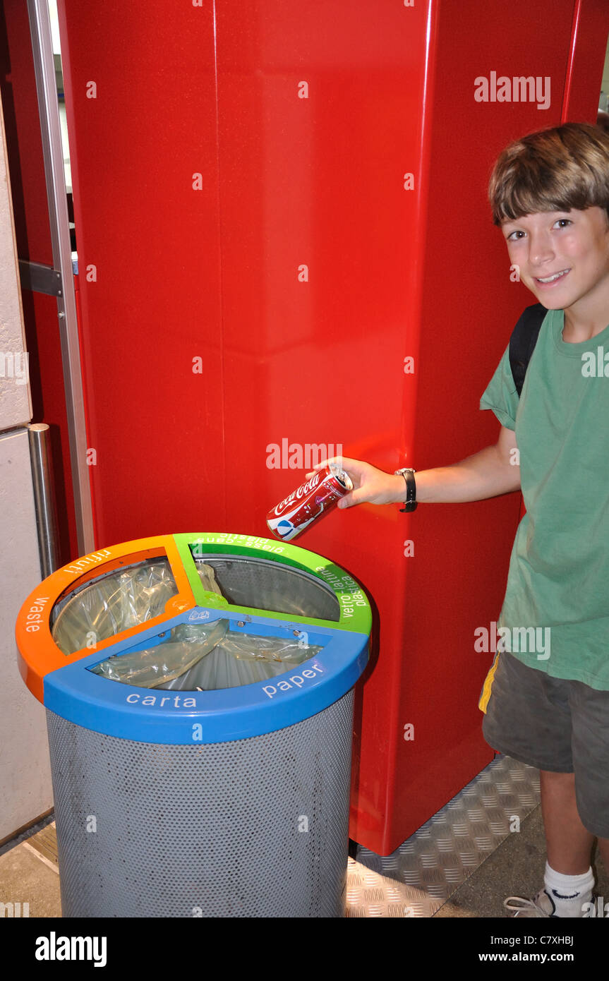 Boy recycling a coke can at airport in Venice, Italy Stock Photo