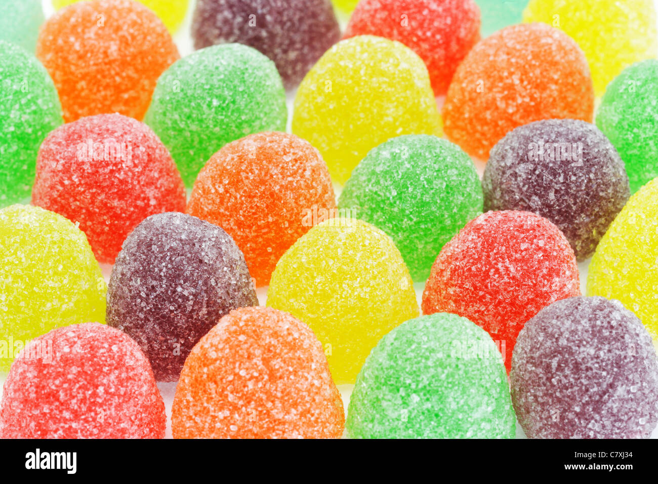Rows of multicolor sugar coated soft jelly candies background Stock Photo